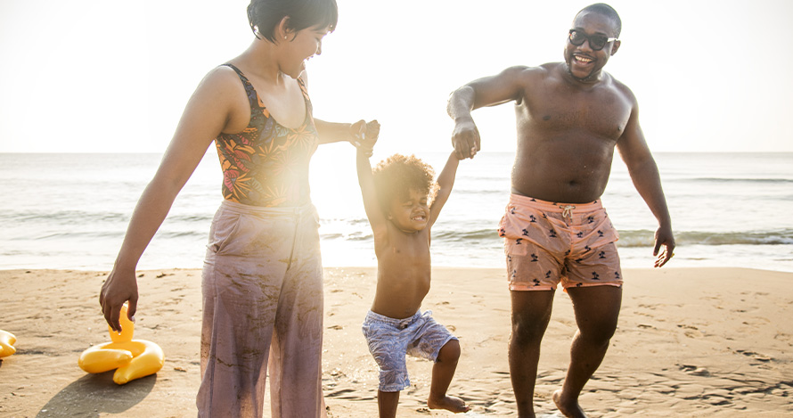 An African American family enjoys time at the beach. 