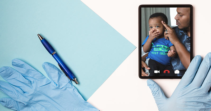 A doctor speaks with a father and son over a cell phone. 