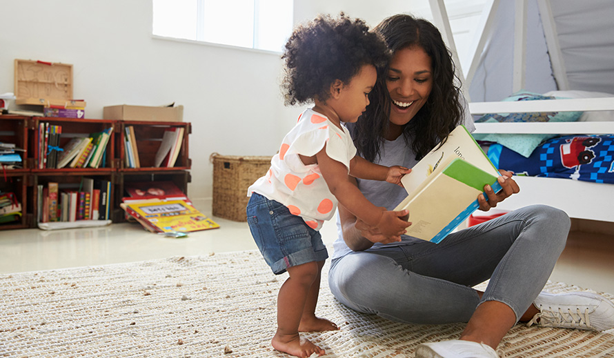 A woman reads to her young daughter.