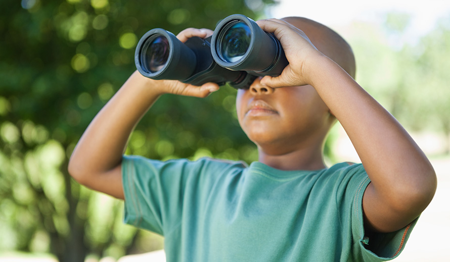 Little boy looking through binoculars.