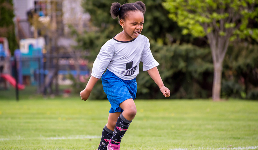 Little girl playing soccer.