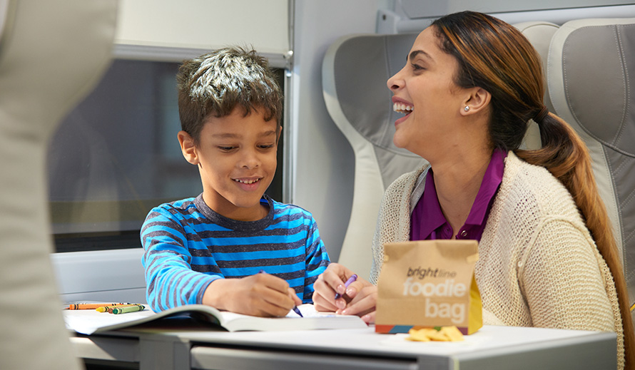 Un niño y su mamá disfrutando de actividades a bordo del tren Brightline.