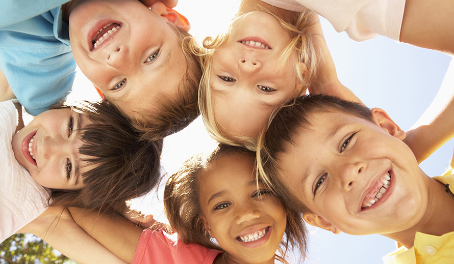 A group of friends smile in a circle.