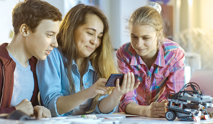 A mother reviews an app on her phone with her children.