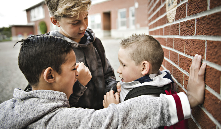 A couple of older kids gang up on a younger child.