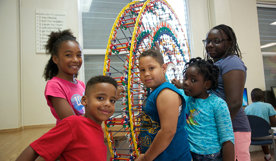 Los niños afroamericanos construyen una mini noria durante el campamento de verano.