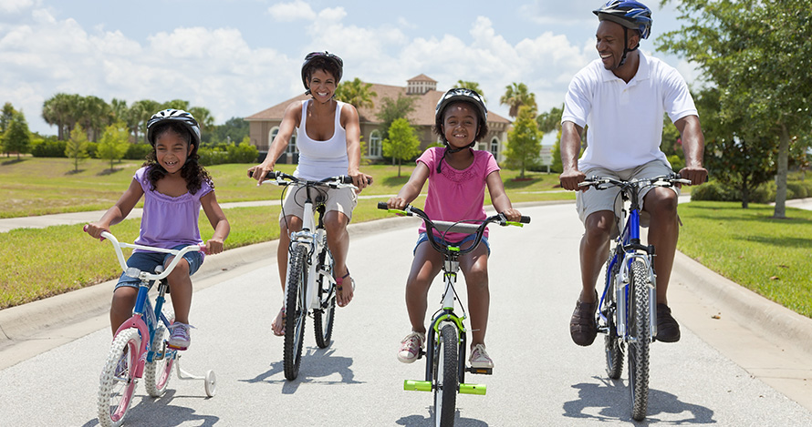 An African American family takes a summer bike ride. 