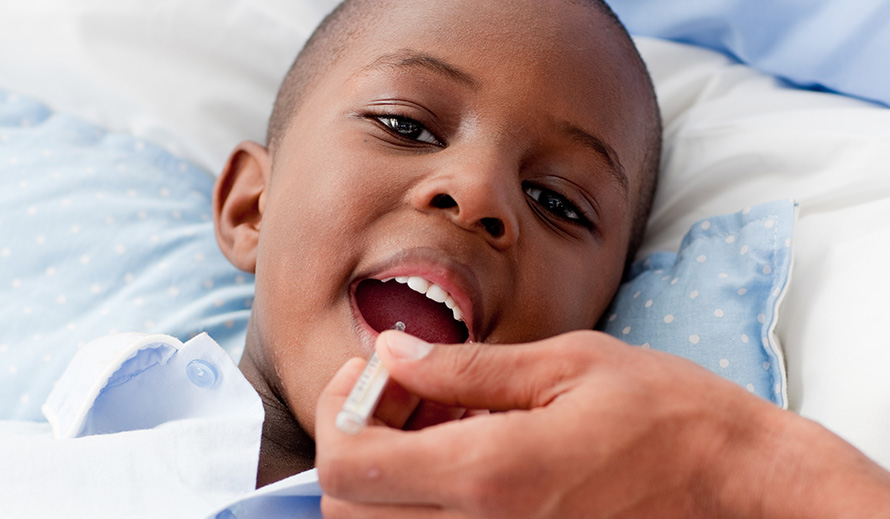 Little boy getting his temperature taken.