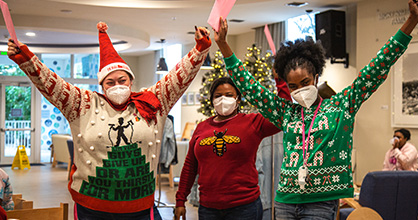 Lotus House employees celebrate with their Help the Helpers gifts. 