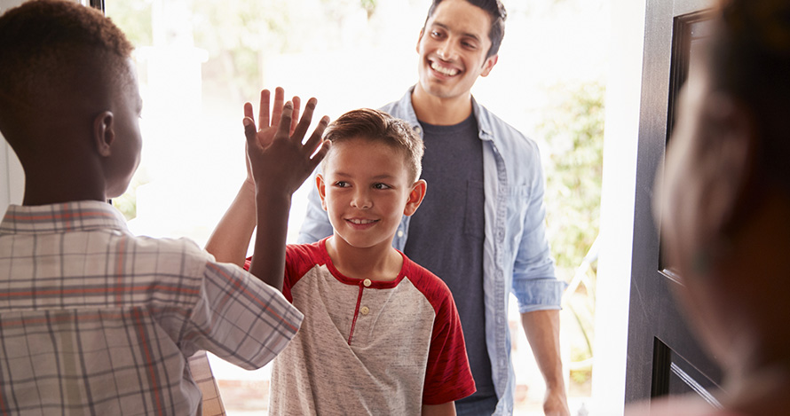  Un niño afroamericano le da la bienvenida a su amigo hispano para una cita de juegos.