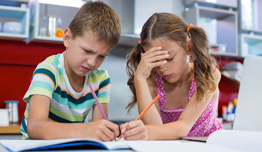 Frustrated young brother and sister doing homework