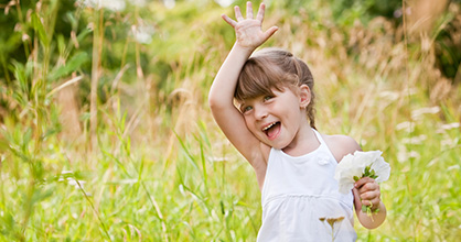 Niña sonriente despidiéndose