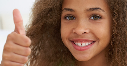 Girl smiling giving a thumbs up