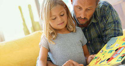 Father and daughter reading together at home.