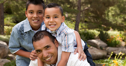 Happy dad and sons outdoors.