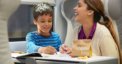 A boy and his mother enjoy activities aboard a Brightline train.