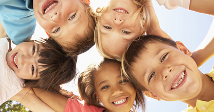 A group of friends smile in a circle. 