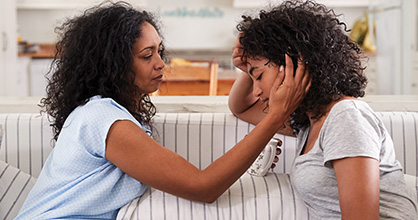 A mother comforts her daughter who is going through a hard time. 