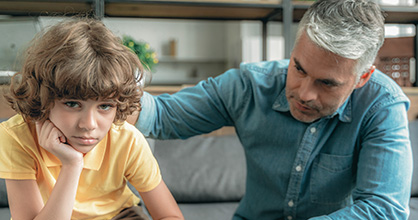 Father comforts boy in emotional distress. 