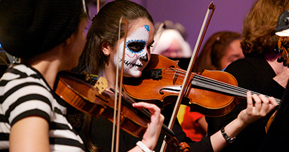 Violinist in mime costume playing her violin 