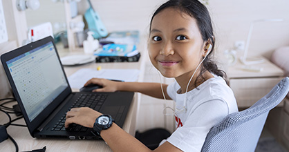 A young girl enjoys online learning from home. 