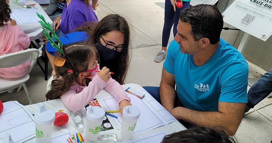 The Children's Trust President and CEO James R. Haj sitting with children at the 2021 Miami International Book Fair.